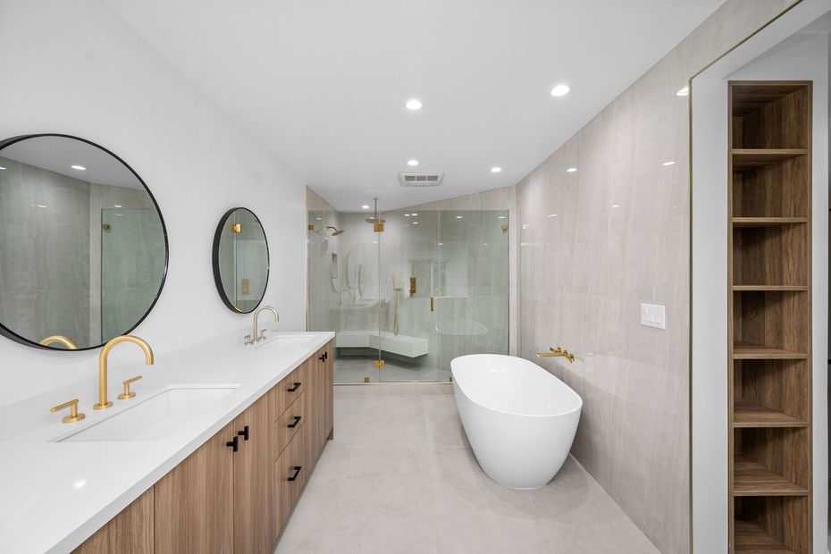 A bathroom with a bathtub , sink , mirror and shelves.
