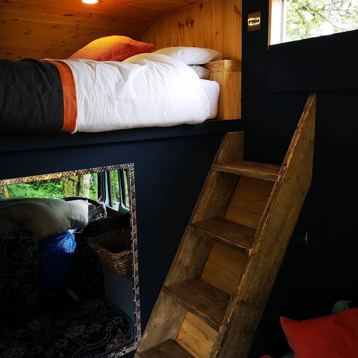 A bunk bed with a wooden ladder leading up to it