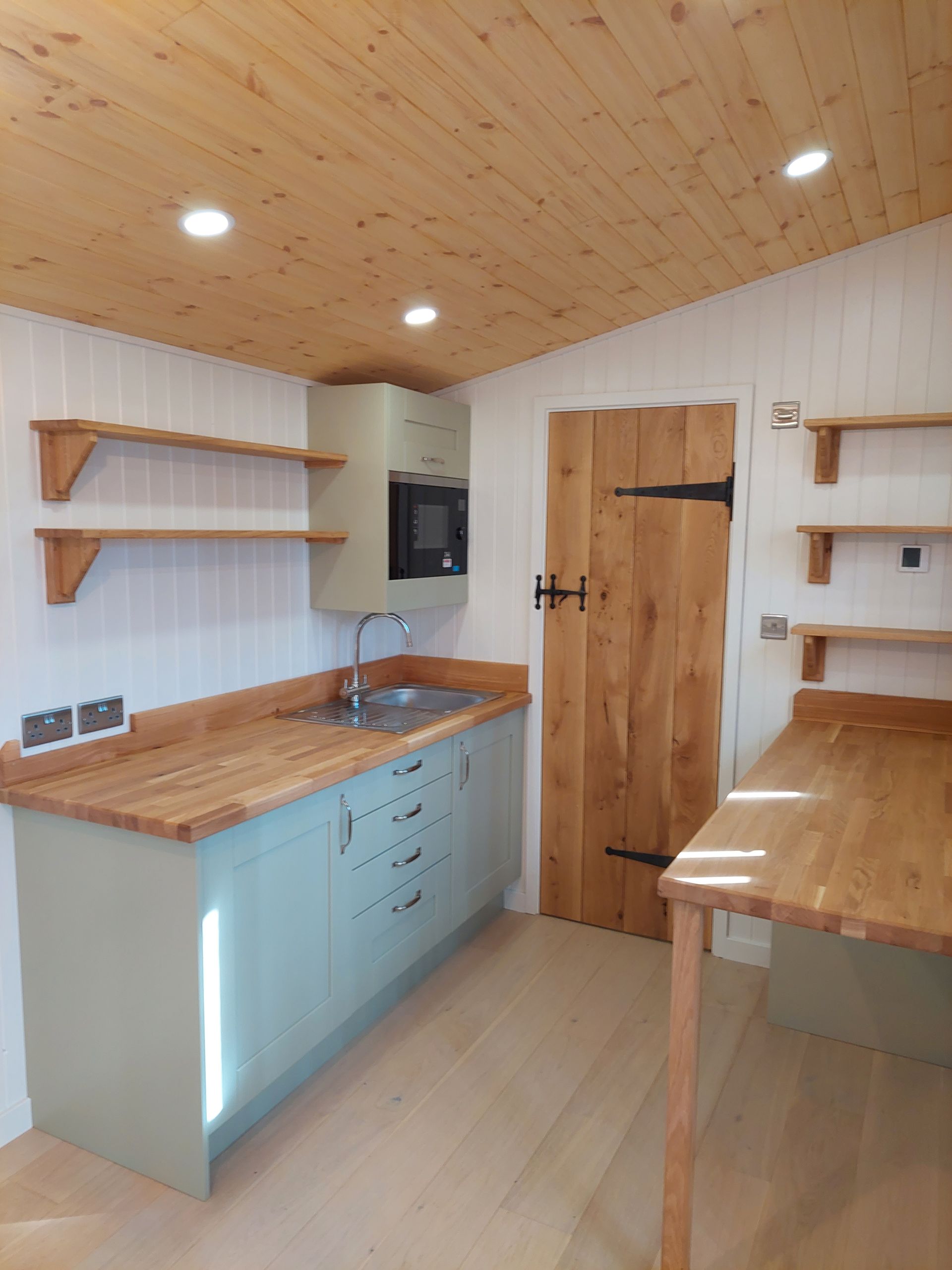 A kitchen with wooden cabinets and a wooden table