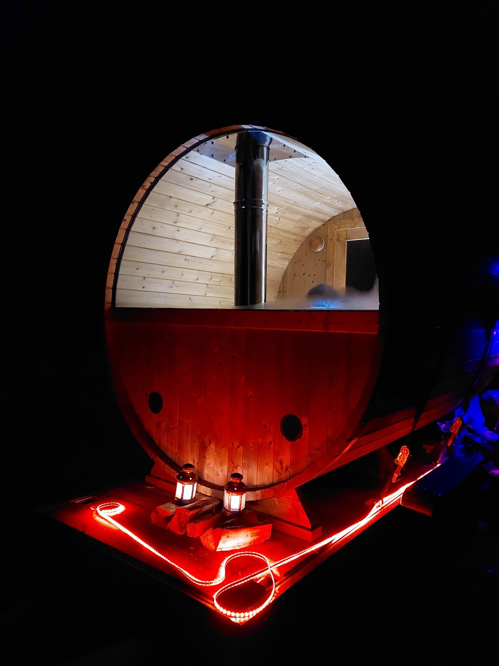A red barrel with a hole in the middle is lit up with red lights.