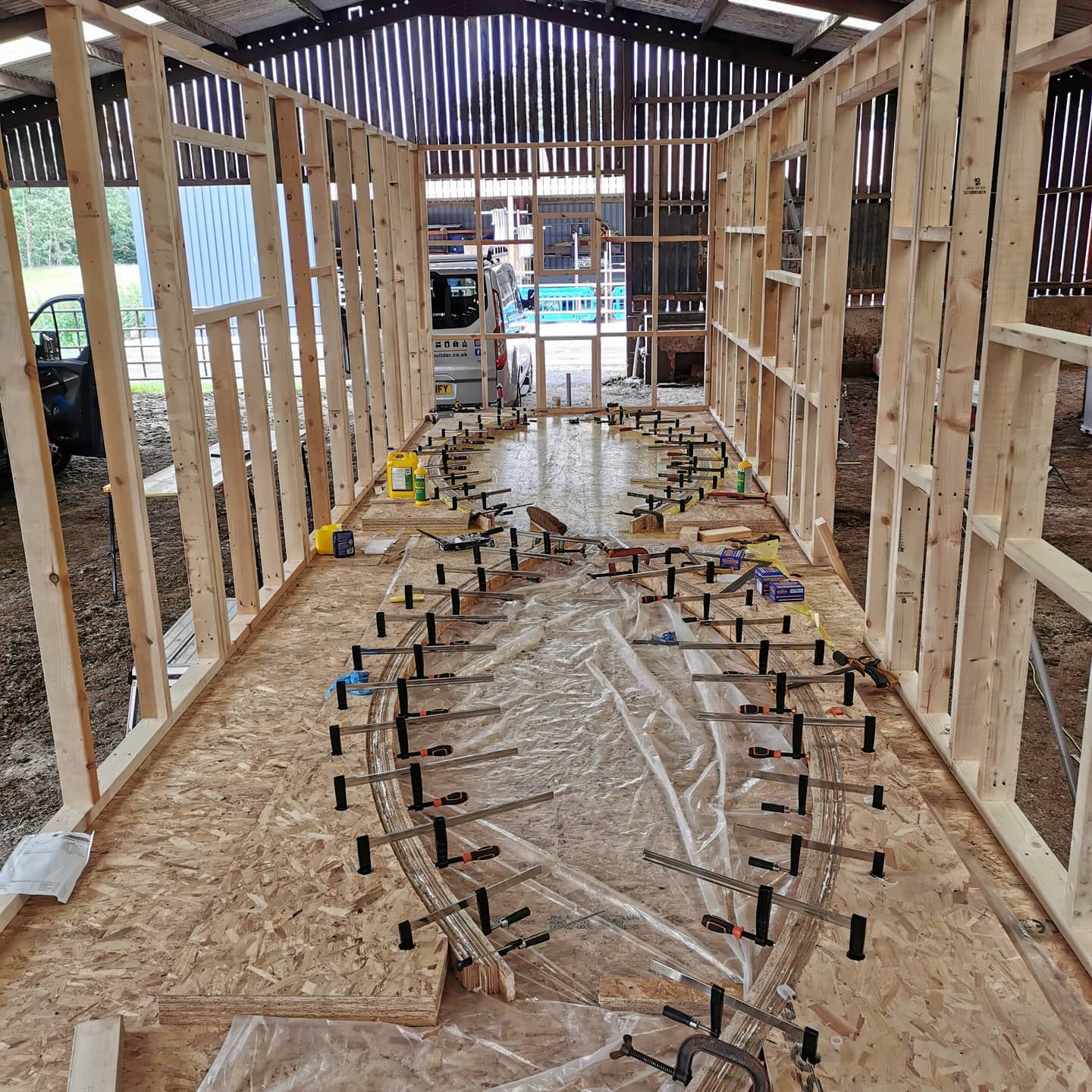 A large wooden structure is being built in a barn.