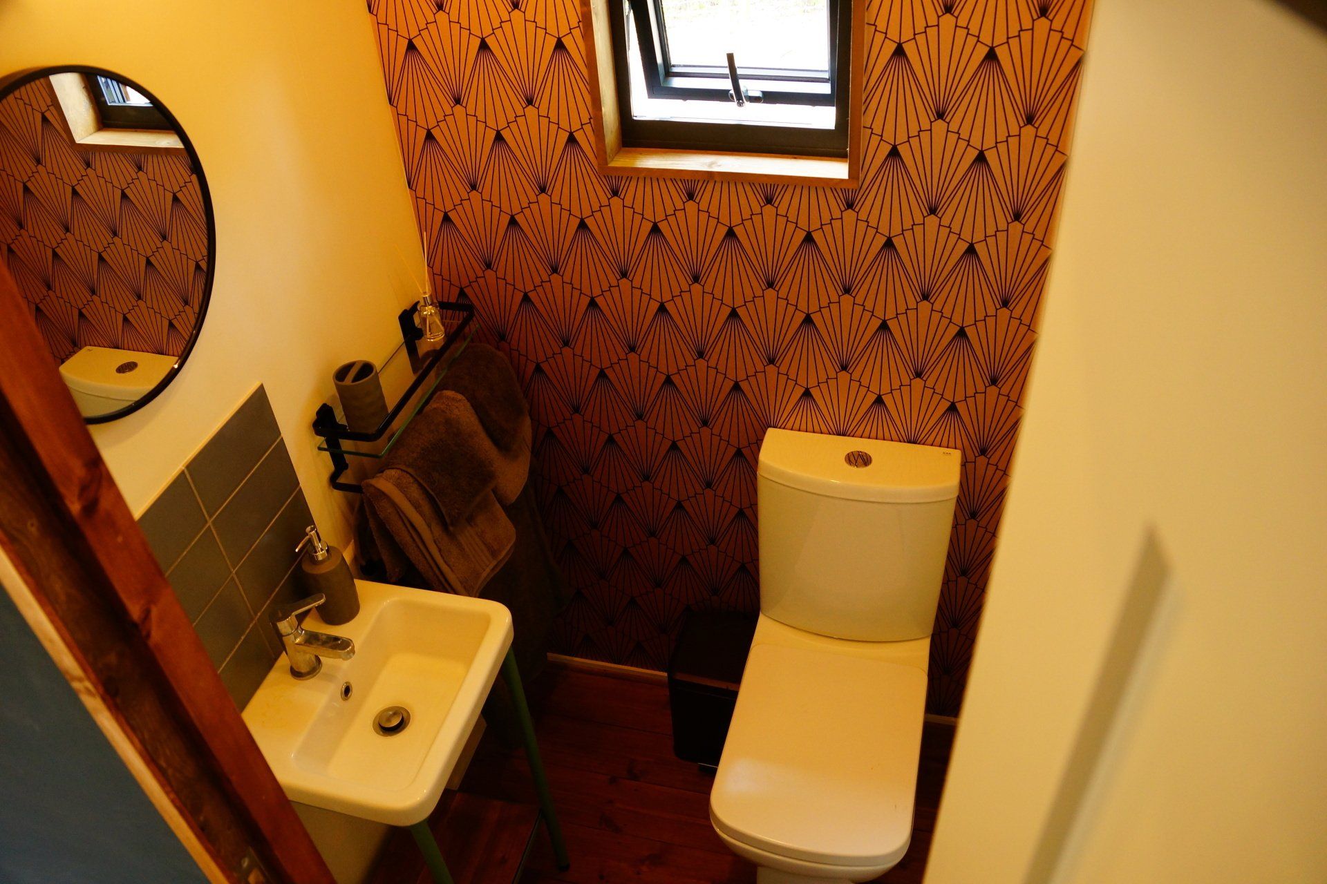 A bathroom with a toilet a sink and a mirror