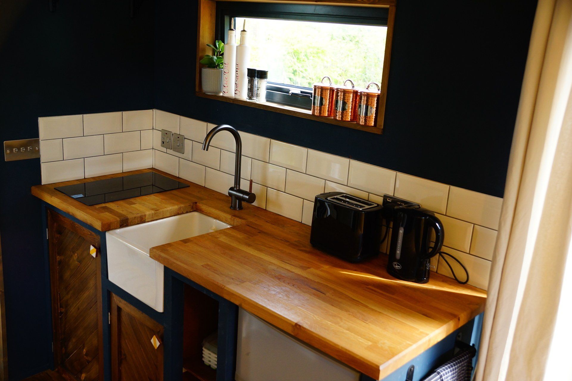 A kitchen with a sink , toaster , and a window.