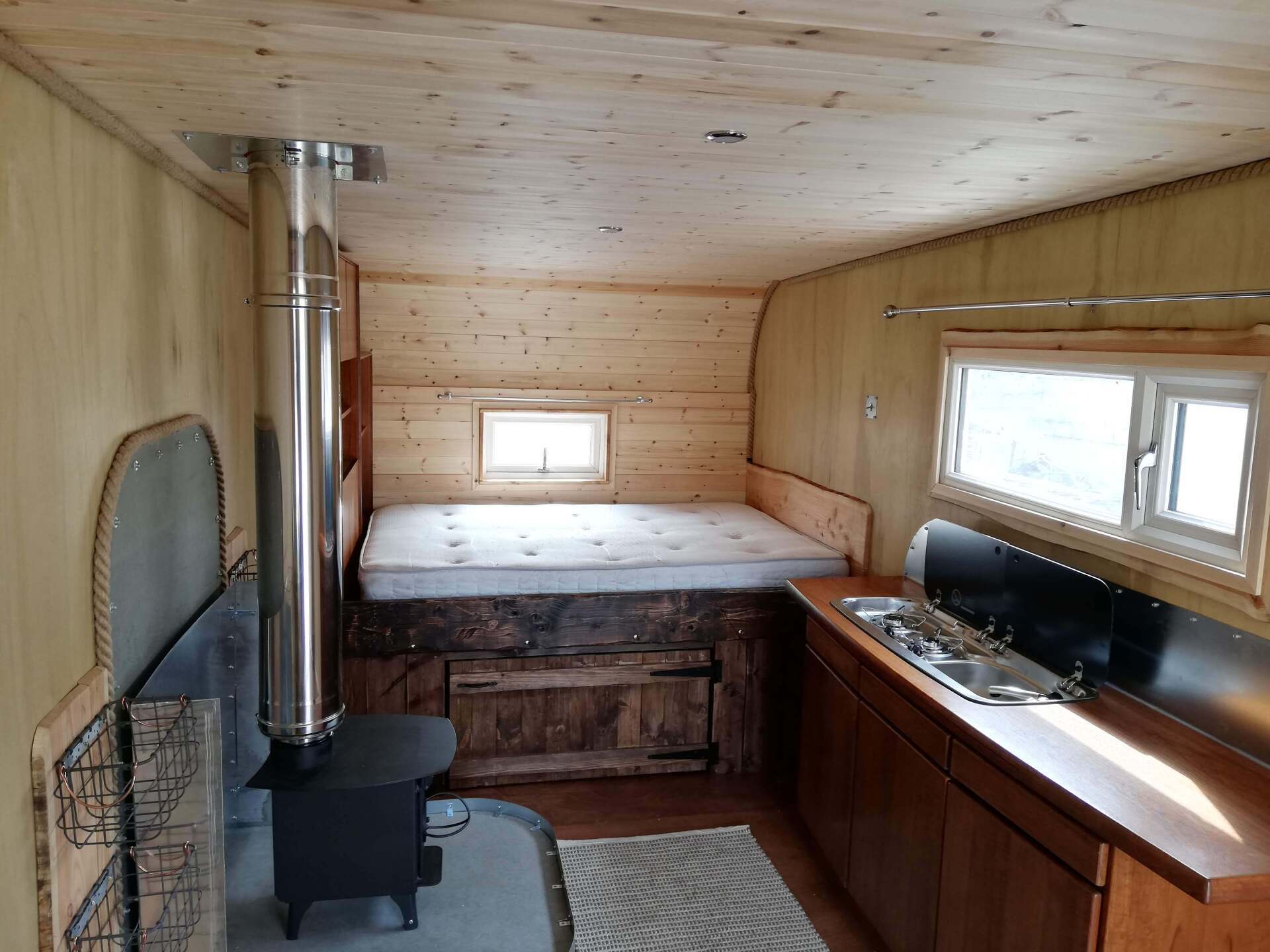 A kitchen with a stove and a bed in it