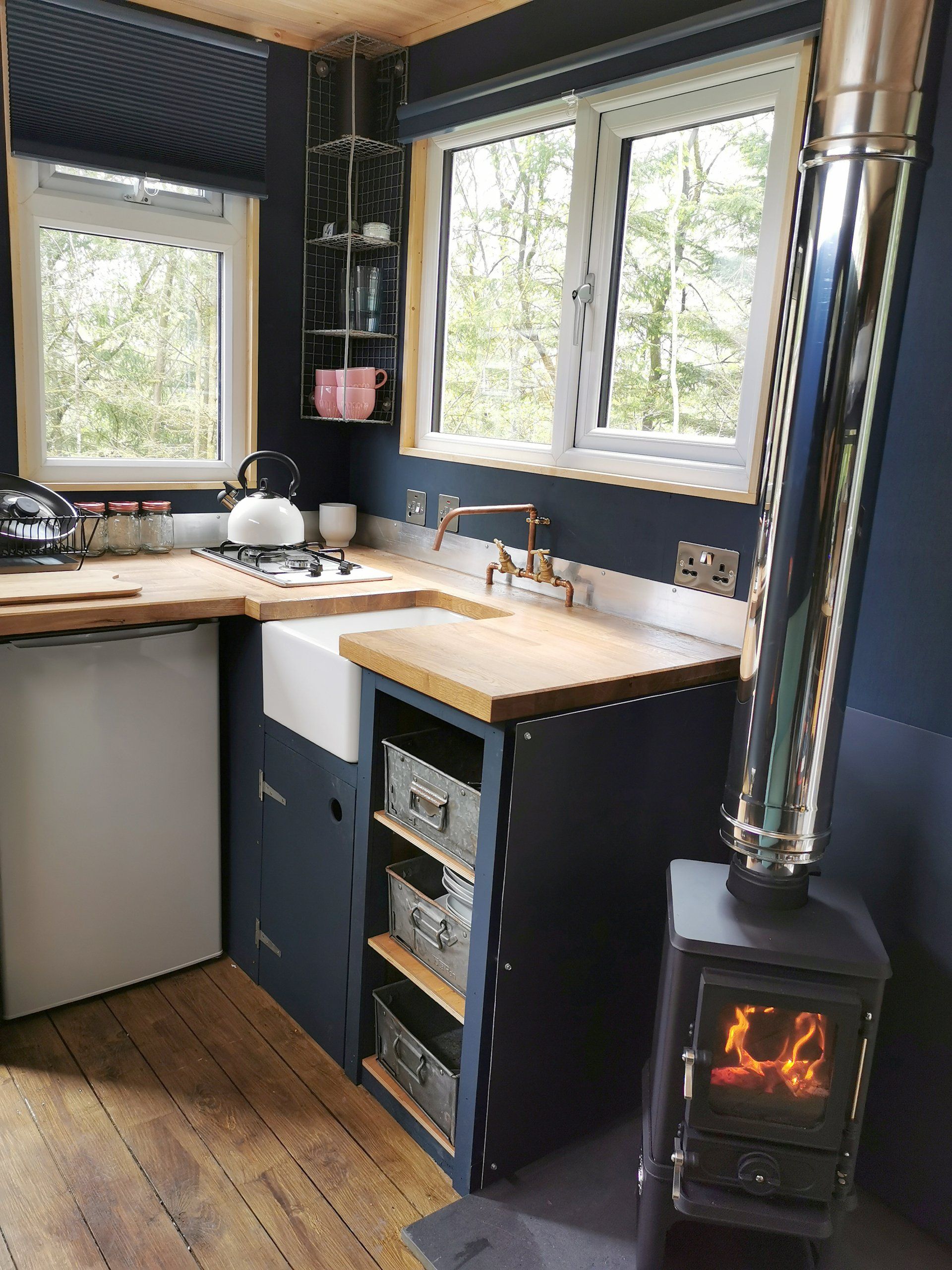 A kitchen with a wood stove and a sink