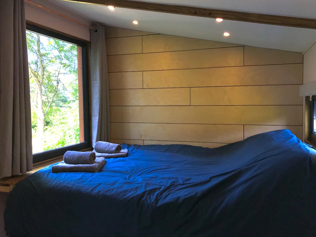 A bedroom with a large bed and a window.