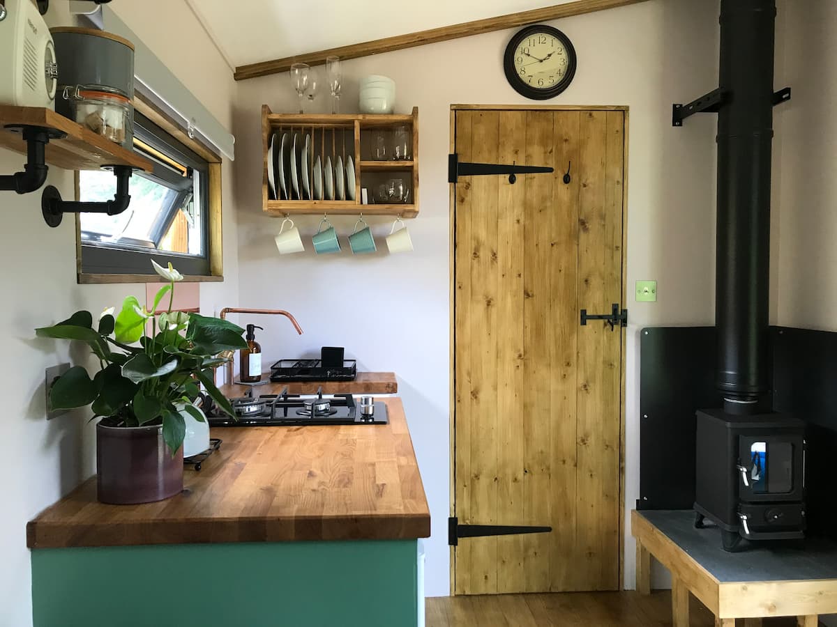 There is a clock on the wall above the door in the kitchen.