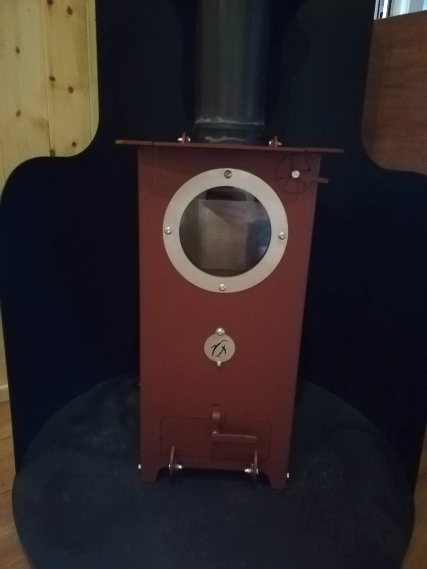 A red stove with a hole in the middle of it