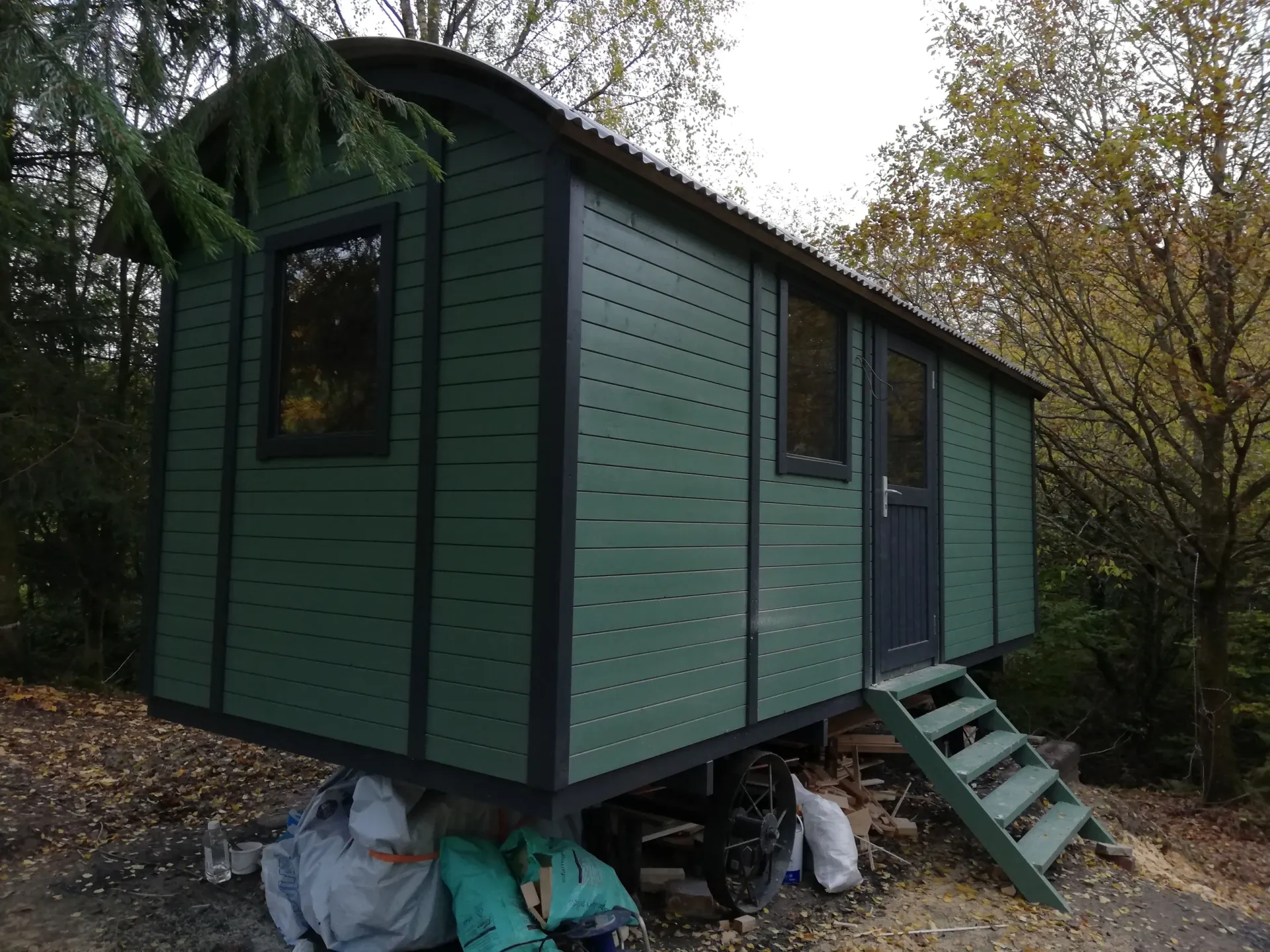 A green shed with stairs leading up to it
