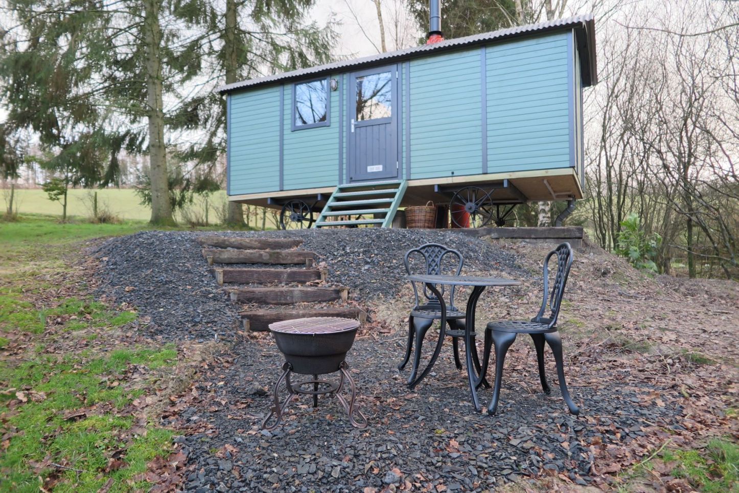 A tiny house with a table and chairs in front of it.