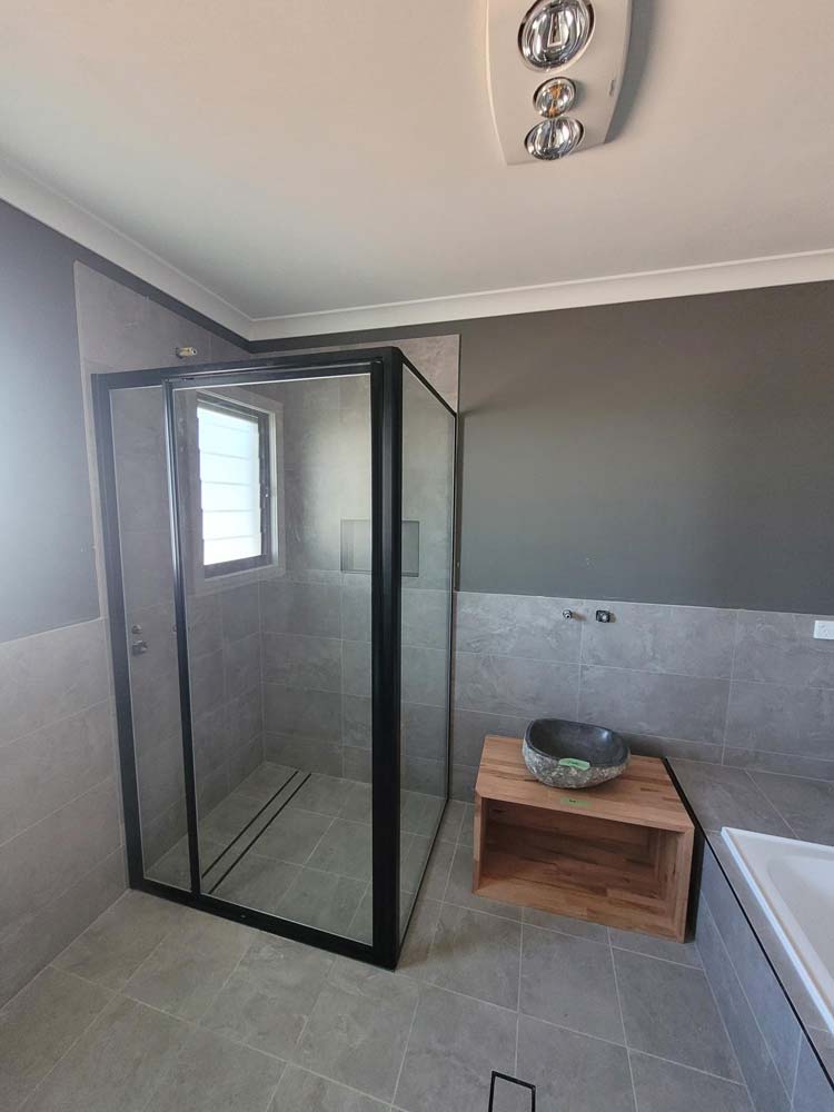 Glass Cubicle Beside A Sink And Bathtub — Shower Screens in Dubbo, NSW