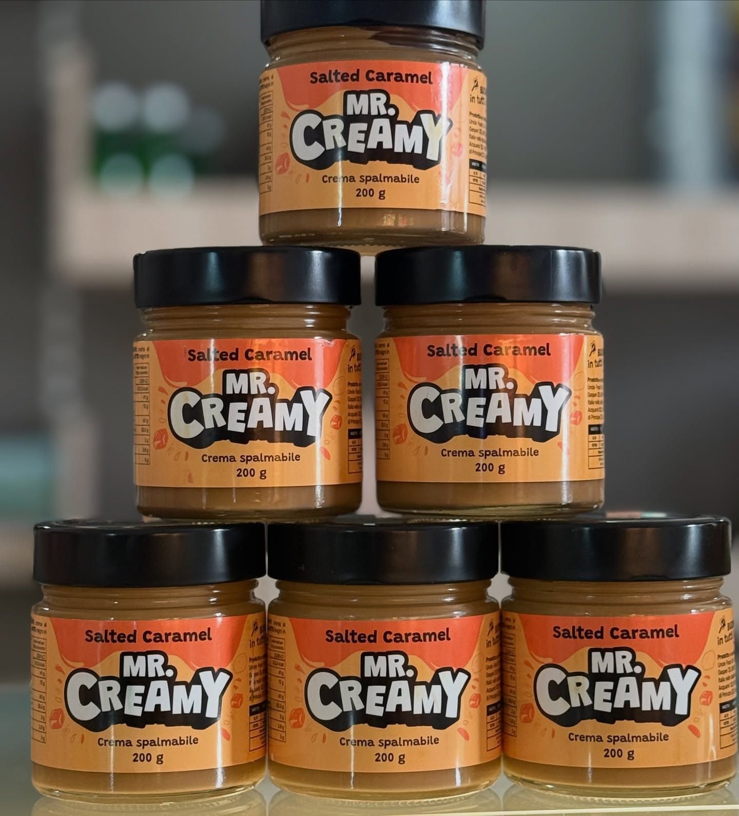 Sei barattoli di caramello salato cremoso sono impilati uno sopra l'altro.
