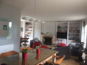 Un séjour avec une table , des chaises , une cheminée et une télévision.