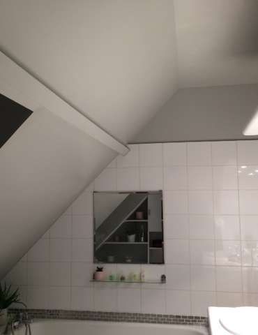 Une salle de bain avec baignoire , lavabo et miroir.