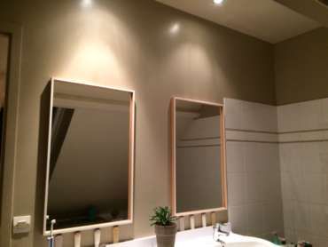 Une salle de bain avec deux miroirs et un lavabo.