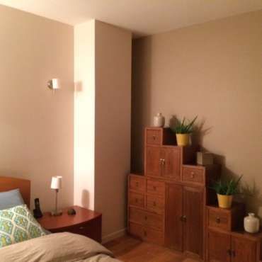 Une chambre avec un lit, une table de nuit et une commode
