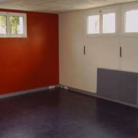 Une pièce vide avec des murs rouges et un sol noir.