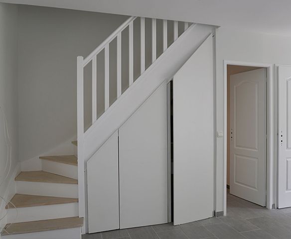 Il y a un escalier avec une porte en dessous.