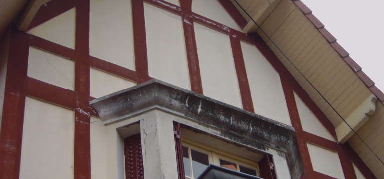 Une maison avec un balcon sur le côté.