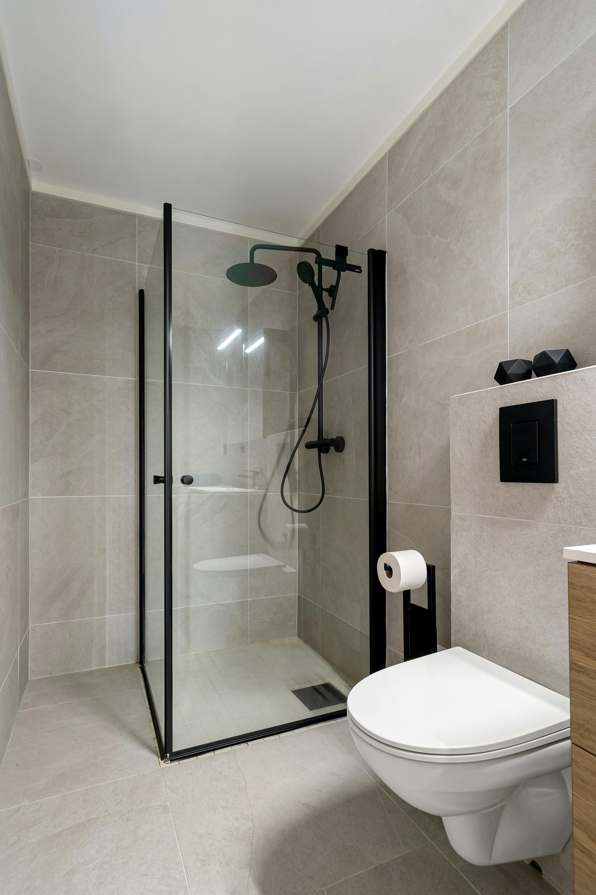 Bathroom with a glass shower enclosure and a wall-mounted toilet.