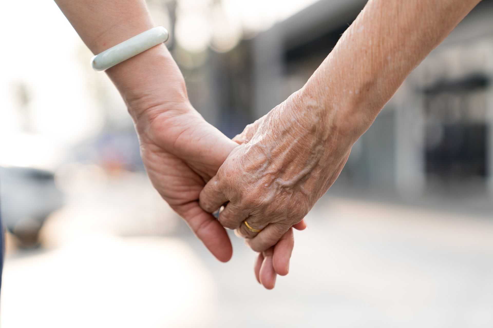 A green urn surrounded by a floral wreath with red and yellow roses in a room with candles.