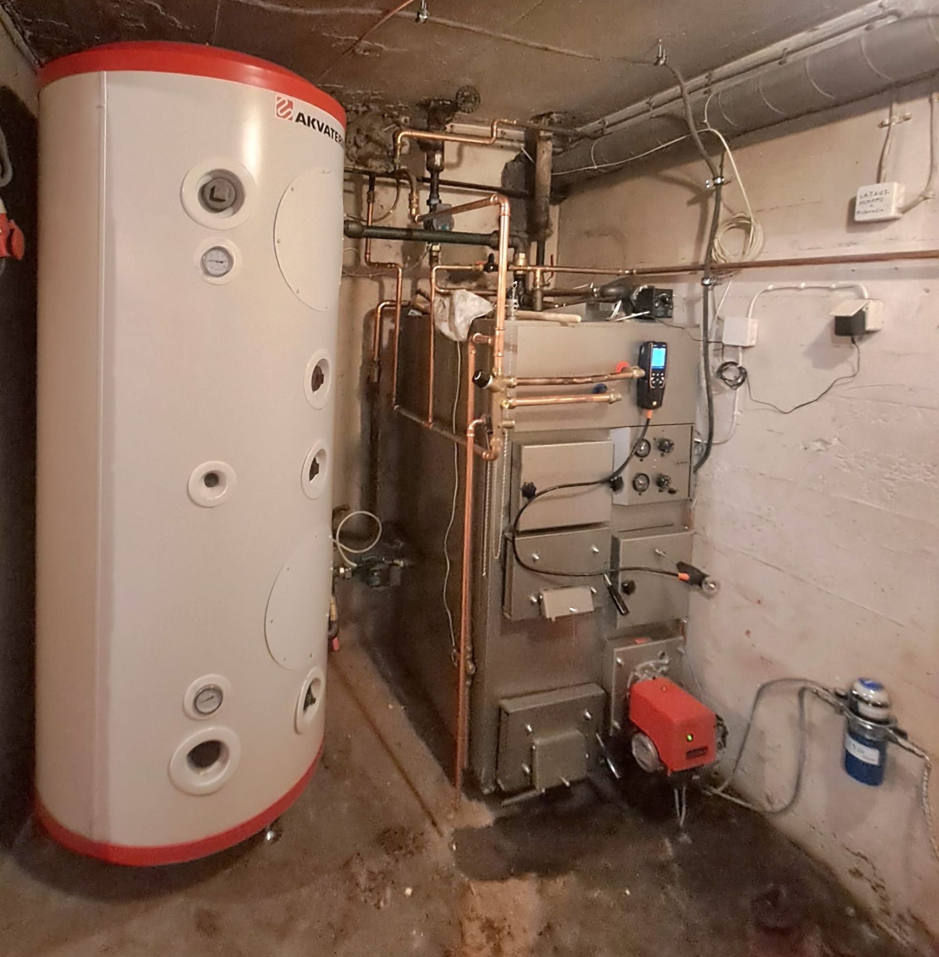 Huone, jossa on suuri valkoinen säiliö ja lämmitin