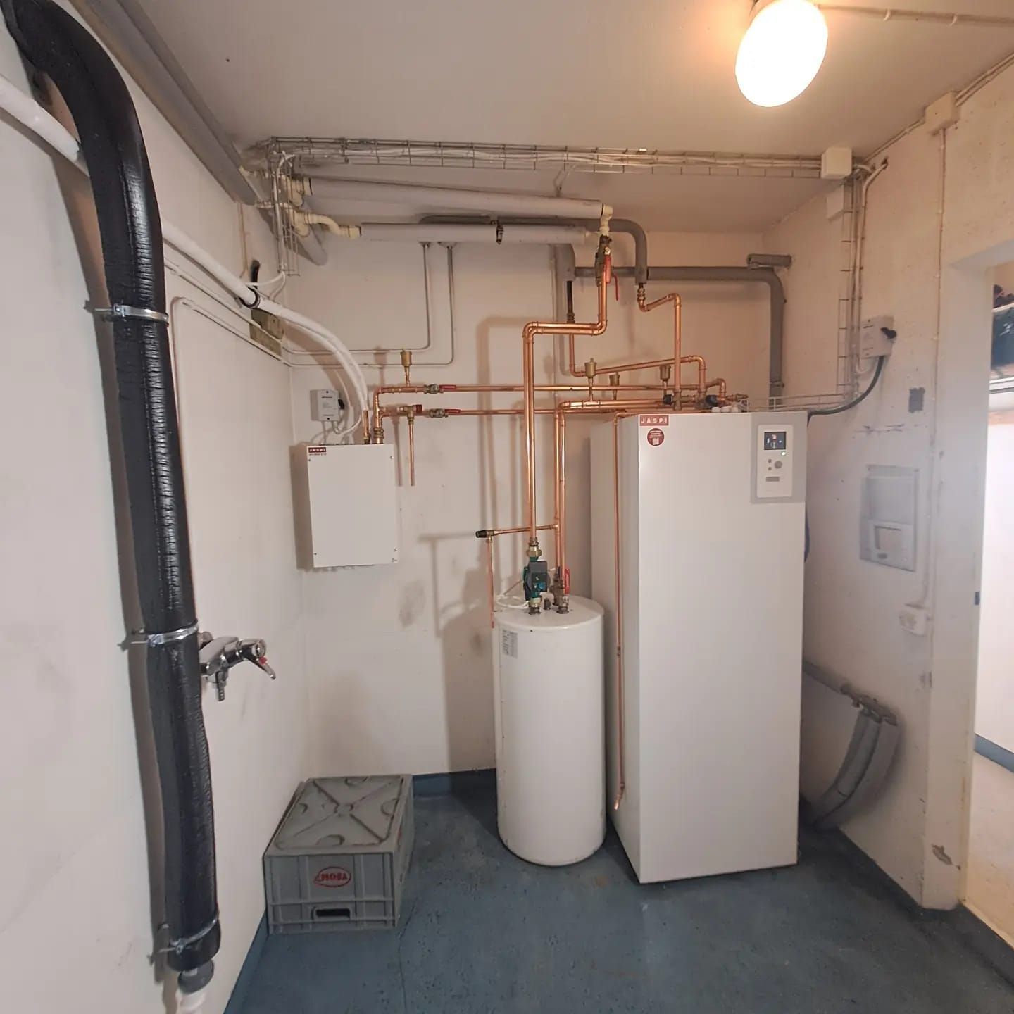 Huone, jossa on vesi-ilmalämpöpumppu ja putkistoa.