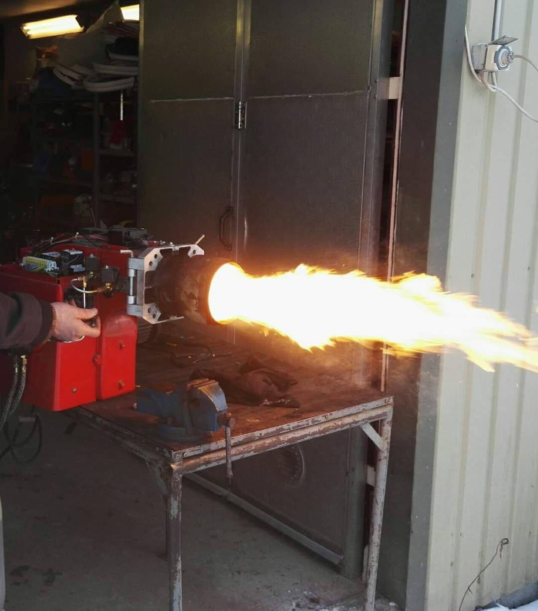 Henkilö käyttää poltinta, josta tulee liekki