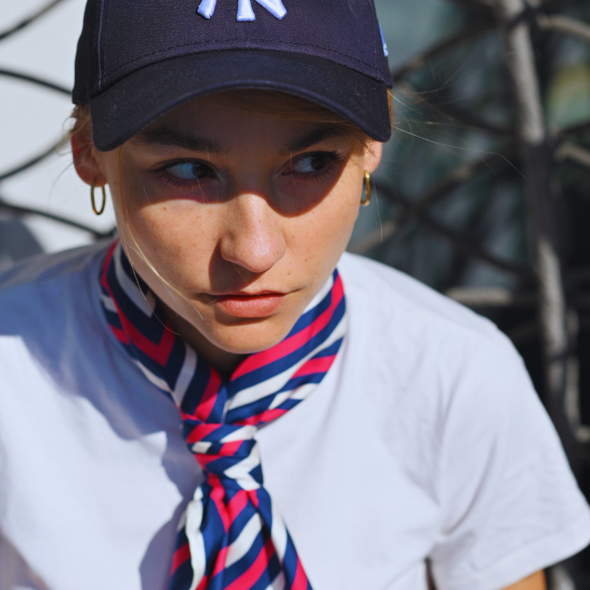 A model wearing a red and cream large silk scarf as a top