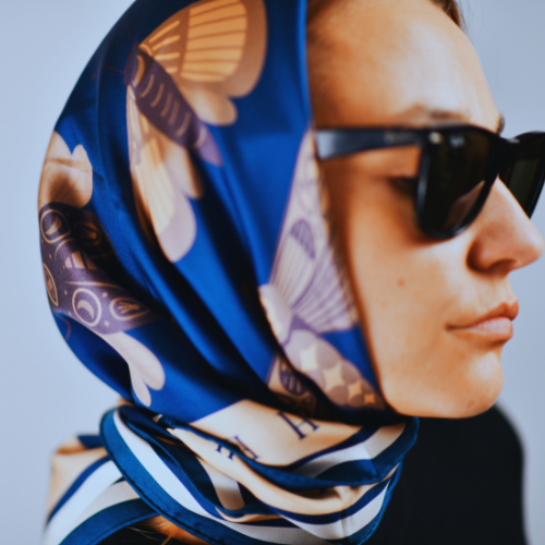 A model wearing a large silk scarf for women around her head
