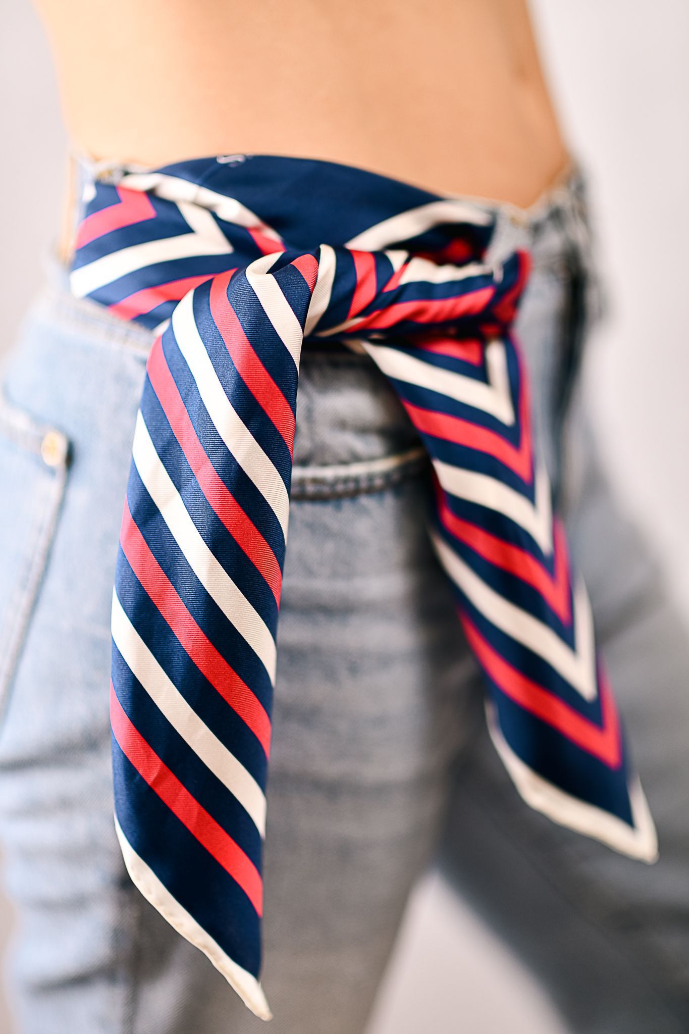 a silk scarf tied around jeans
