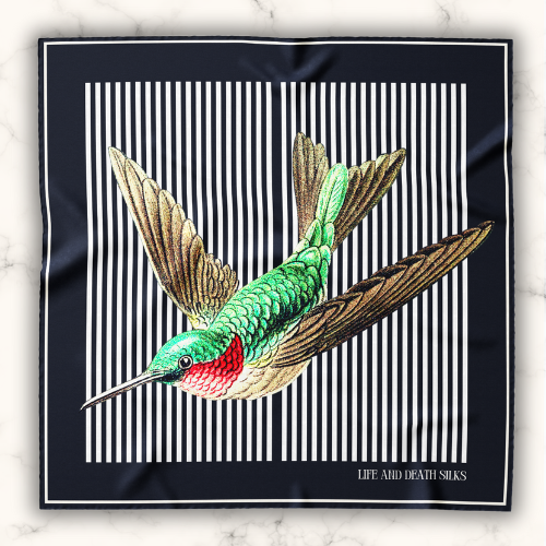 A model wearing a limited hummingbird large silk scarf for women