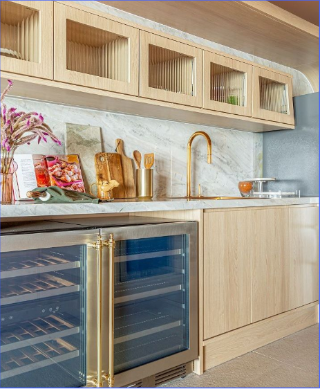 Sofisticação e funcionalidade unidas no ponto de encontro do seu lar. Bancada e balcão de cozinha planejada de alto padrão com adega embutida e detalhes em dourado - Batel Select.