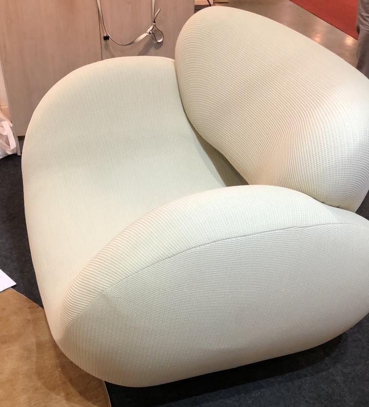 Poltrona branca em tecido bouclé, design contemporâneo com linhas arredondadas e acabamento de alto padrão, ideal para ambientes sofisticados, disponível em loja de móveis de Curitiba.