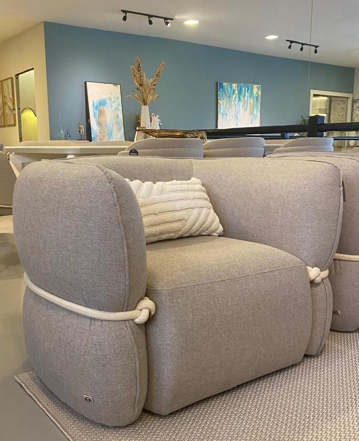 Poltrona orgânica de luxo com design contemporâneo, linhas curvas e acabamento sofisticado, perfeita para ambientes elegantes, disponível em loja de móveis de alto padrão em Curitiba. Detalhe em corda abraçando a poltrona. 