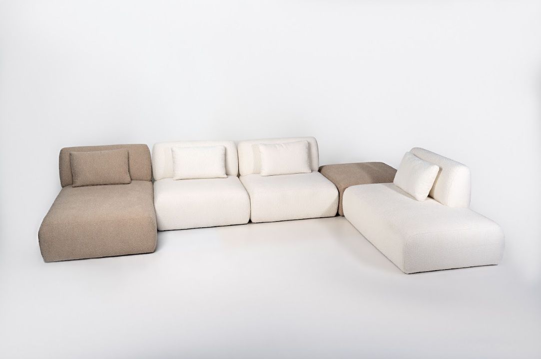 Sofá boucle branco e marrom de alto padrão em tecido bege claro com almofadas soltas, design contemporâneo minimalista com estrutura baixa e linhas retas para salas modernas em Curitiba.