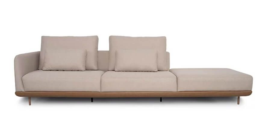 Sofá modulado cor creme com chaise lateral e base de madeira, ideal para sala de TV sofisticada e conforto da família.