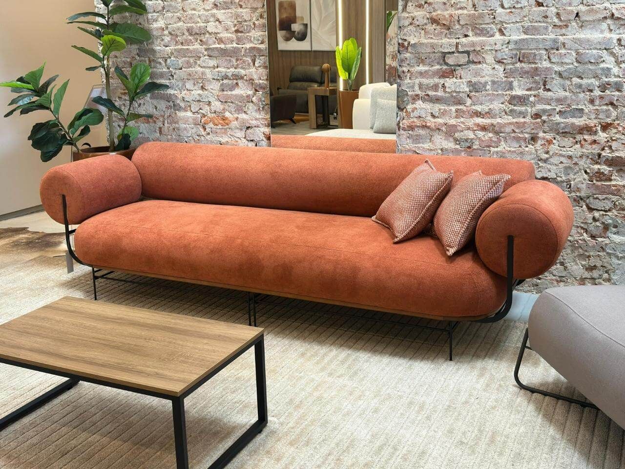 Sofá orgânico curvo de alto padrão em Curitiba, revestido em tecido verde musgo, encosto contínuo e linhas suaves, ideal para salas sofisticadas e modernas.