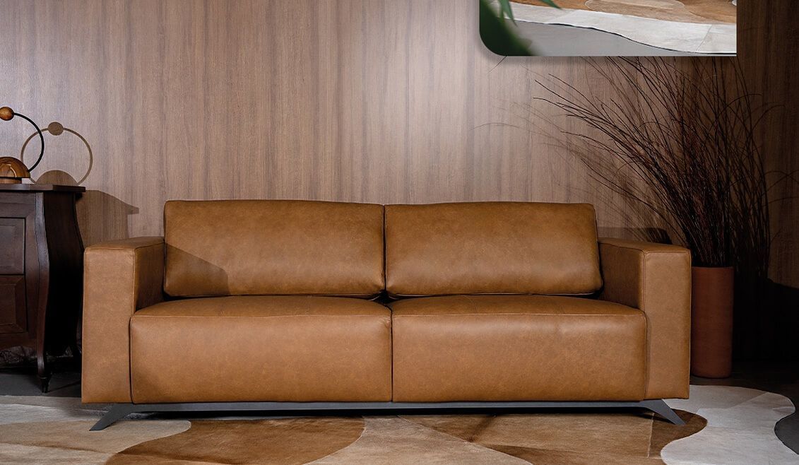 Sofá modular de couro marrom, alto padrão clássico, com base em aço carbono preta fosca, disponível na loja Batel Select. Design sofisticado, acabamento premium e estrutura resistente, ideal para ambientes elegantes. Entrega para todo o Brasil.