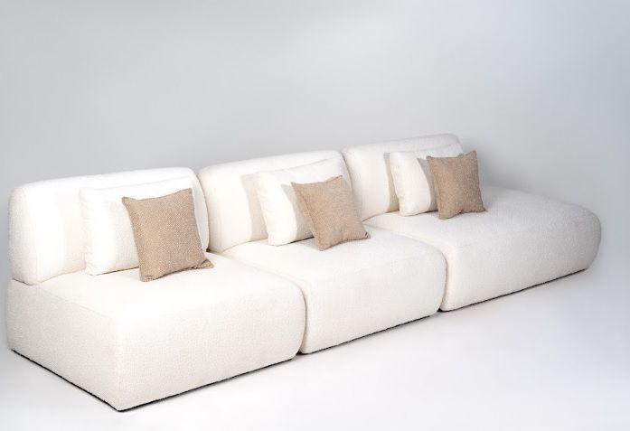 Sofá moderno  de alto padrão em Curitiba, formato modular minimalista com chaise, revestido em tecido claro, múltiplas almofadas decorativas.