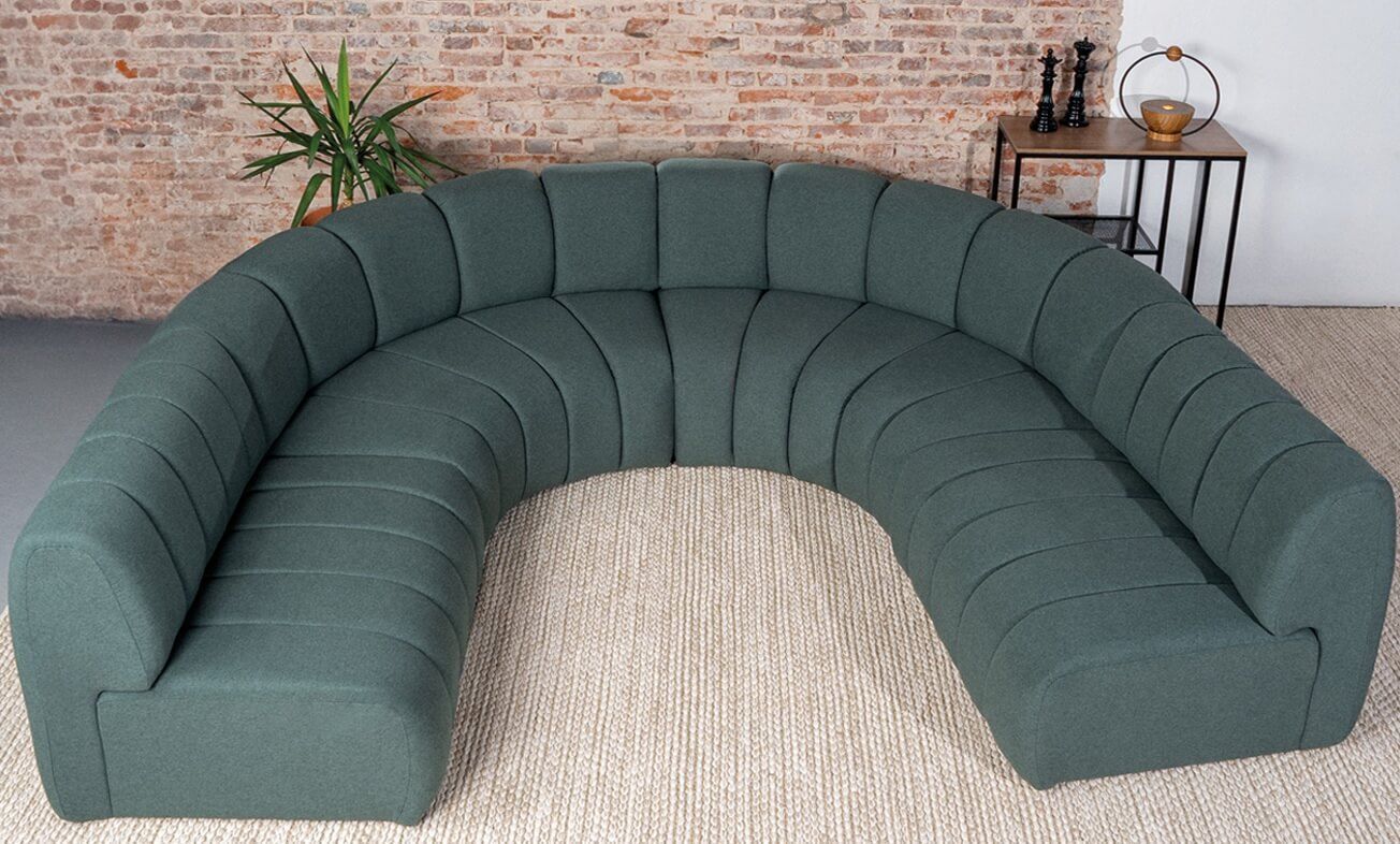 Sofá curvo orgânico de alto padrão em verde escuro, design contemporâneo com linhas suaves e acabamento premium. Estrutura robusta, conforto excepcional e detalhes sofisticados, ideal para salas modernas e ambientes sofisticados que buscam exclusividade e elegância em móveis de luxo.