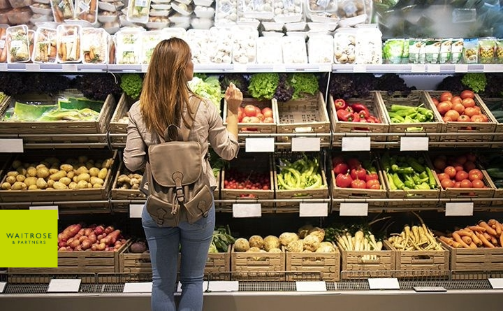 A woman is shopping for vegetables in a grocery store.