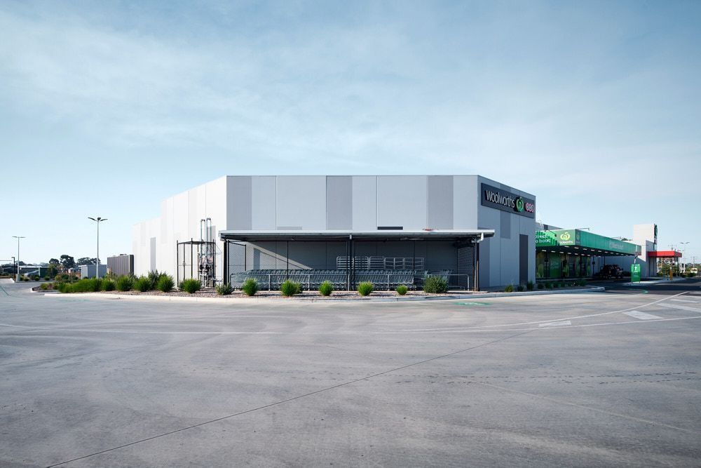 A Light-colored, Angular Retail Building With a Parking Lot  — Quarrell Civil Construction In Congupna, VIC