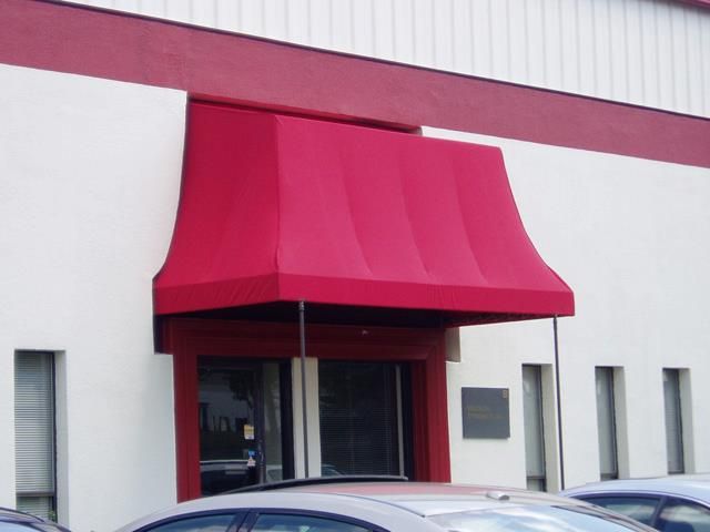 Red awning over a doorway, contrasting against the white building exterior and red trim