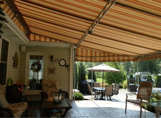 Beige and brown striped awning over a patio with outdoor furniture