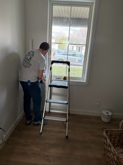 Sean Simmonds prepares to install window treatments on a window - simmonds blinds and drapes, ky