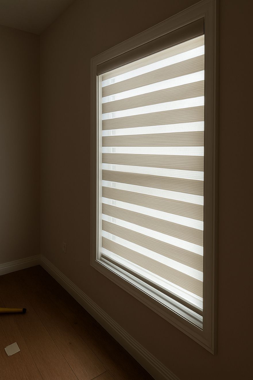 Window with layered shades partially obscuring light. Beige walls, window frame.