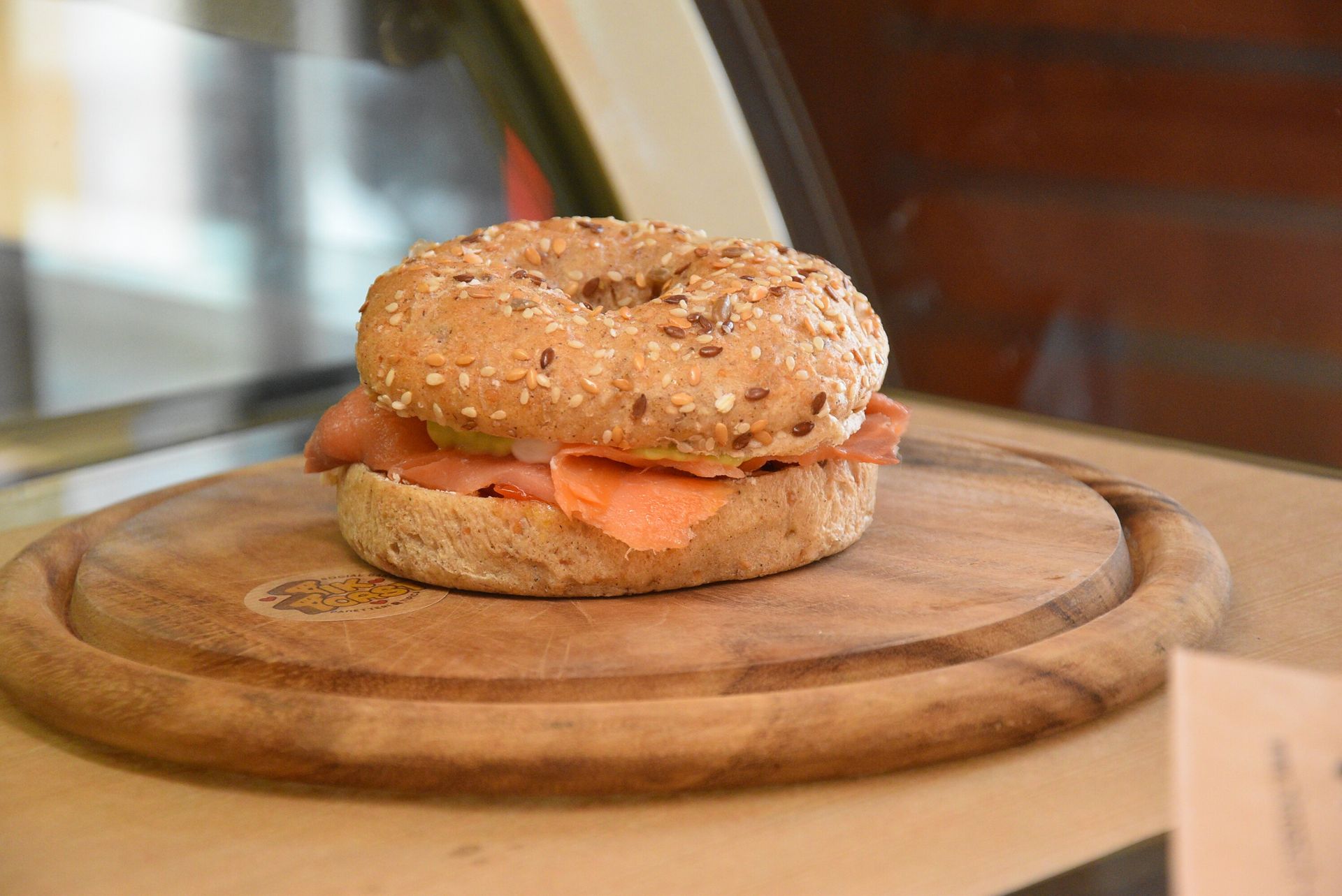 Bagel con salmone affumicato su un tagliere di legno.