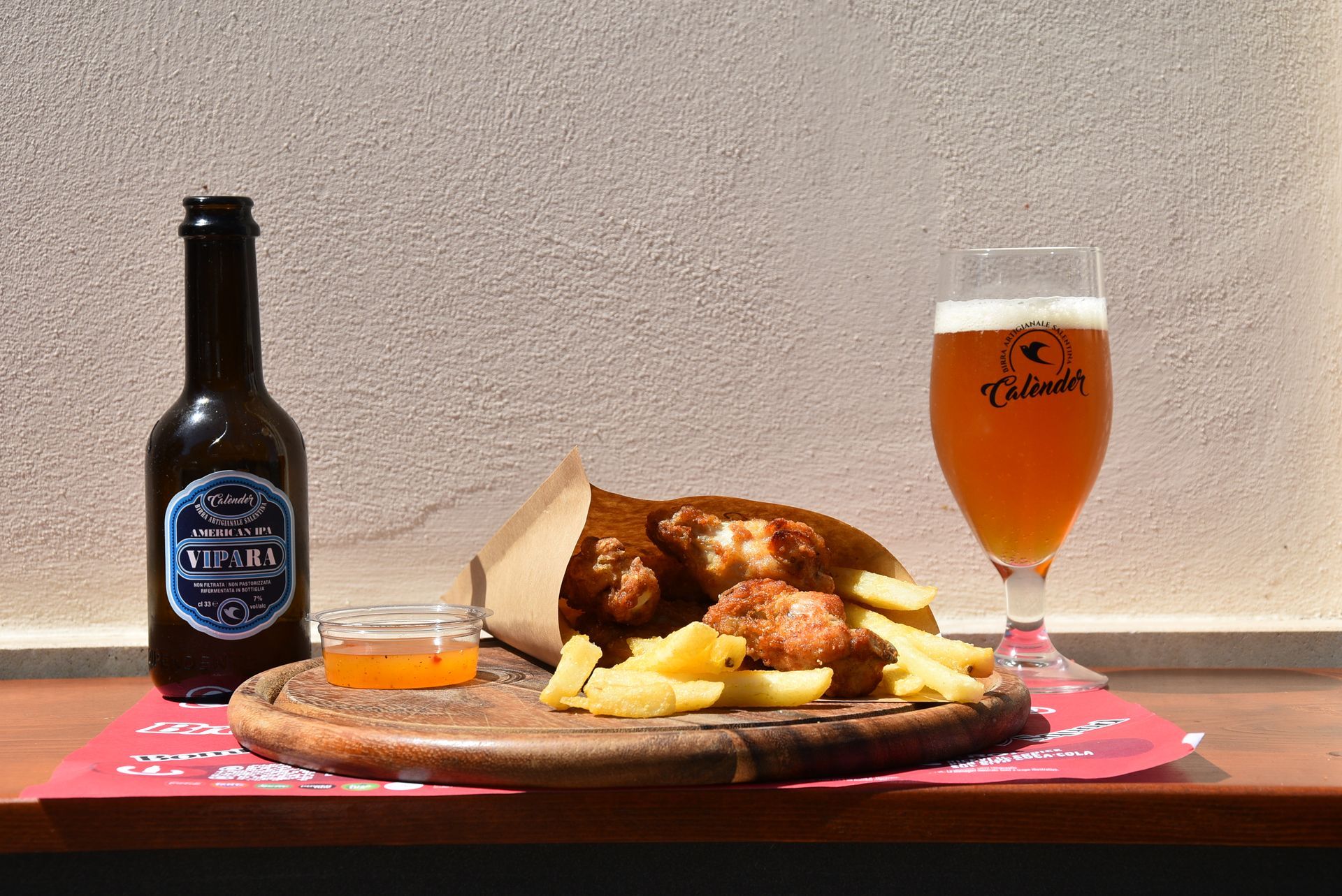 Donna che mangia un hamburger seduto a un tavolo all'aperto, in una giornata di sole.