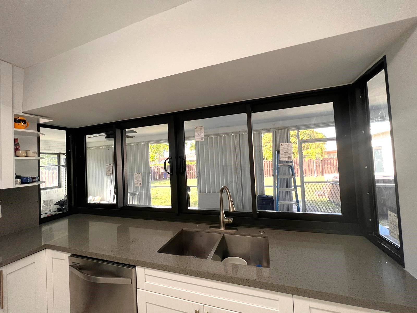 A kitchen with a sink and a lot of windows